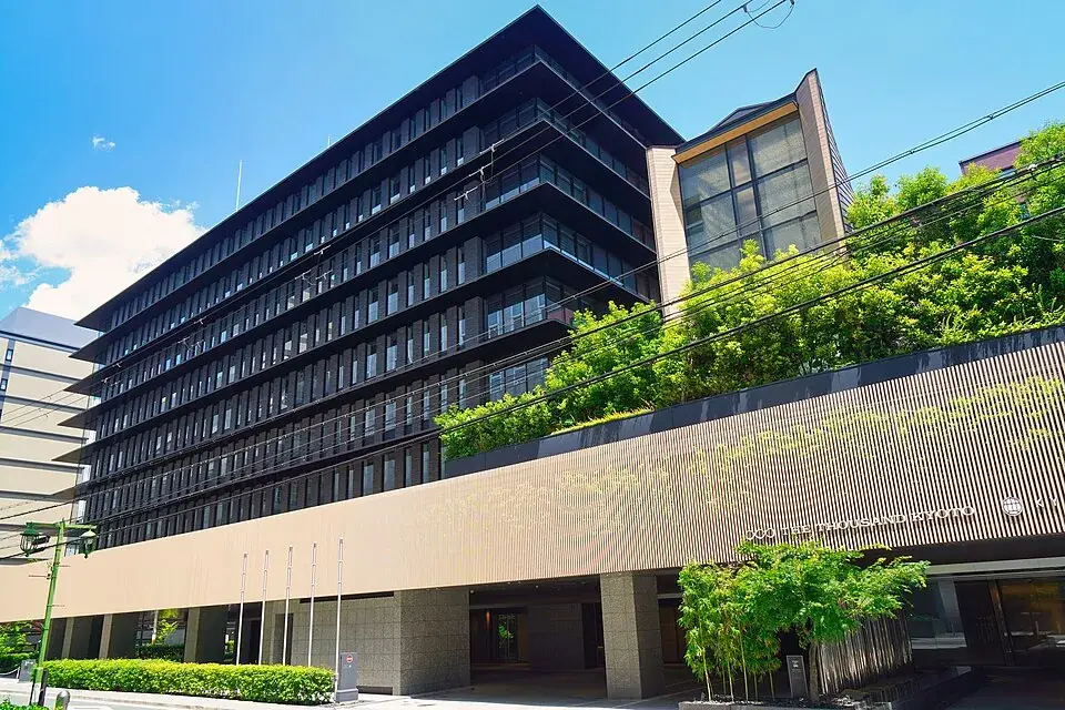 The Thousand Kyoto’s long dark facade with a planted terrace, by Kyoto Station